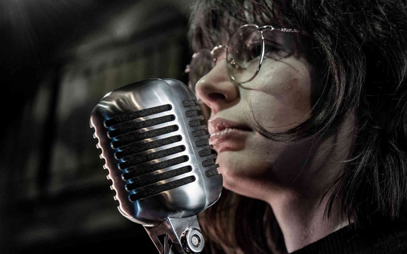 Ca sĩ hát với micro Shure 55SH